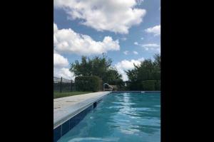 una piscina con agua azul y nubes en el cielo en Orlando getaway, en Orlando