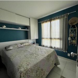 a bedroom with a bed and a blue wall at Cumbuco Ap VGSUN 402 in Cumbuco