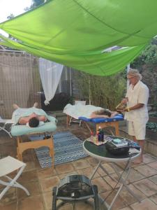 um homem debaixo de uma tenda verde com duas pessoas na cama em Villa des Delices em Grimaud