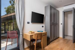 a room with a desk and a tv and a chair at PERUNIKA BED & BREAKFAST in Mošćenička Draga