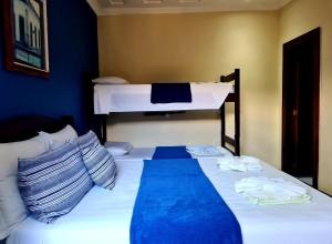 a bed in a room with two bunk beds at Pousada Konquista in Paraty