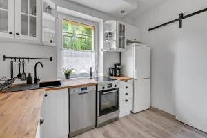 eine Küche mit weißen Geräten und einem Fenster in der Unterkunft Pokoje Gdynia Witomińska in Gdynia