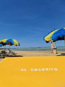 two umbrellas and chairs on a beach with the ocean at A Casa Letizia San Salvo Marina in Marina di Montenero