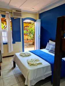 um quarto azul com uma cama com toalhas em Pousada Konquista em Paraty