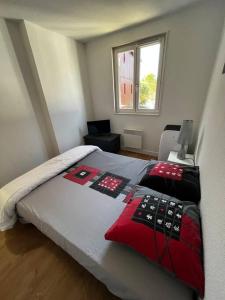 una camera da letto con un letto con cuscini rossi e neri di Le Nid du Teich a Le Teich