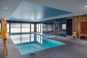 ein großer Pool in einem Gebäude in der Unterkunft DOMITYS LA CALYPSO in Brest