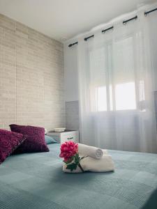 a bedroom with a bed with a towel and flowers on it at AITA CASA BARBATE in Barbate