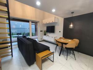 una sala de estar con un sofá y una mesa en Superior Laguna Beskidow Pilot's Studio! Sauna&Gym! Air Condition!, en Zarzecze