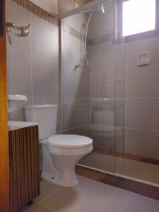 a bathroom with a toilet and a glass shower at Analândia: para dormir e sonhar in Analândia
