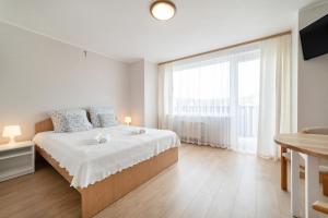 a white bedroom with a bed and a large window at Nord Jastarnia in Jastarnia +34 photos