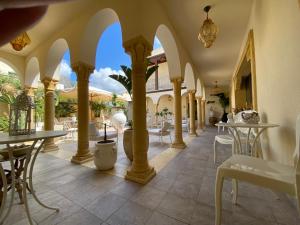 a restaurant with columns and tables and chairs at RIAD Comfort Rooms in San Vito lo Capo
