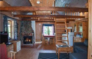 a living room with a fireplace in a log cabin at 2 Bedroom Awesome Home In Backaryd in Backaryd
