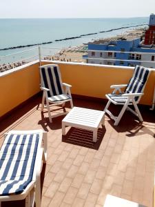 蒙特西爾瓦諾的住宿－La Terrazza sul Mare，俯瞰海滩的阳台配有两把椅子和一张桌子