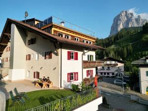 een huis met een balkon met uitzicht op de bergen bij Apartments Heritage House Margherita in Santa Cristina in Val Gardena