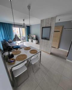 a living room with a table and a couch at Apartament Turkusowy in Międzywodzie