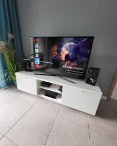 a flat screen tv sitting on a white entertainment center at Apartament Turkusowy in Międzywodzie