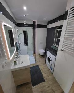 a bathroom with a sink and a washing machine at Apartament Turkusowy in Międzywodzie