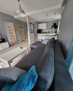 a living room with a couch and a table at Apartament Turkusowy in Międzywodzie