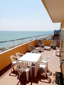 蒙特西爾瓦諾的住宿－La Terrazza sul Mare，一个带桌椅和海滩的阳台