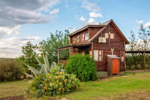 a wooden house with a garden in front of it at Piedramora in Villa Giardino
