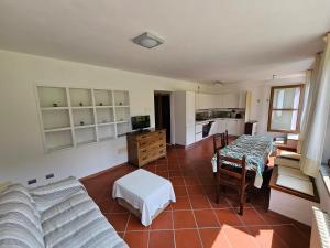 a living room with a couch and a kitchen at Casa Mario Spacious Garden Apartments, Lake Como in Domaso