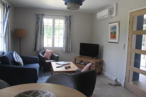 een woonkamer met banken en een tv en een tafel bij Riverside Lodge in Chablis