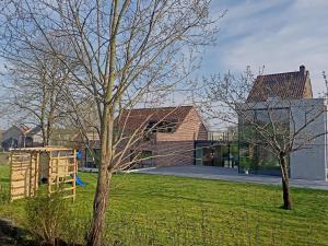 een huis met een speeltuin in een tuin bij The Kettle House - Stable in Sint-Pieters-Leeuw