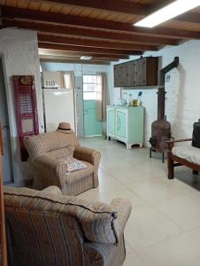 sala de estar con 2 sofás y cocina en Nuestro rincón en San grgorio, a media cuadra de la playa, en San Gregorio de Polanco