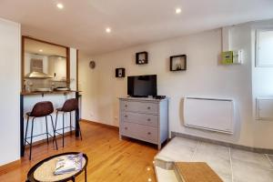 uma sala de estar com uma televisão e uma secretária com cadeiras em Appartement cosy, confortable et idéalement situé em Lyon