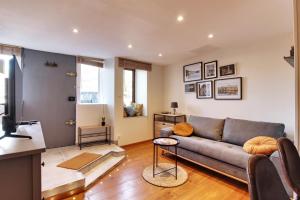 - un salon avec un canapé et une télévision dans l'établissement Appartement cosy, confortable et idéalement situé, à Lyon