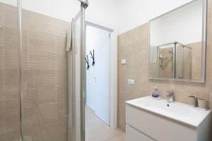 a bathroom with a sink and a mirror and a shower at Borgo alla Pieve Apartments by Garda Facilities in Manerba del Garda