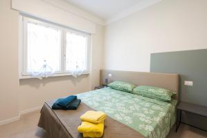 a bedroom with a bed and two windows at Borgo alla Pieve Apartments by Garda Facilities in Manerba del Garda