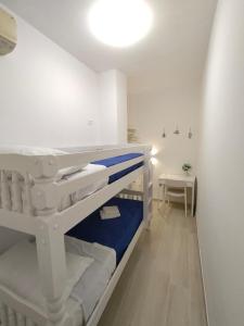 a small room with white bunk beds and a table at Sabbia di Mare in Termoli
