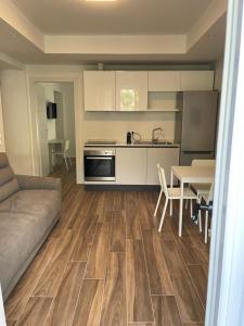 een keuken en een woonkamer met een bank en een tafel bij San Pellegrino Suites in San Pellegrino Terme