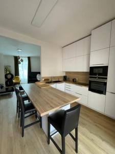 eine Küche mit einem Holztisch und schwarzen Stühlen in der Unterkunft maison 15 mins du Mans in La Suze-sur-Sarthe