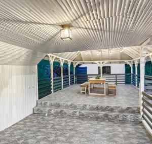 einen Pavillon mit einem Tisch und Stühlen auf einer Terrasse in der Unterkunft Casa Șimon in Leordina