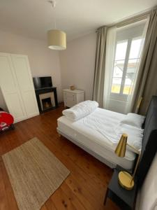 ein Schlafzimmer mit einem weißen Bett und einem Fenster in der Unterkunft maison 15 mins du Mans in La Suze-sur-Sarthe