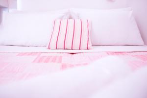 斯普利特的住宿－坦卡瑞瓦公寓酒店，白色的床,配有粉红色和白色条纹的枕头