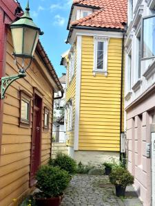 żółty dom ze światłem ulicznym przed nim w obiekcie Knøsesmauet Apartment w Bergen