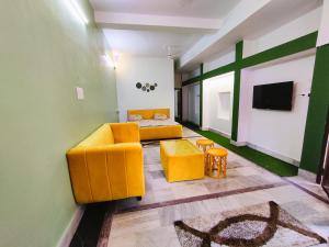 a living room with a couch and a tv at Yellow Homestay - Modern 2BHK AC stay in Jabalpur