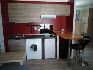 a kitchen with a washing machine and a table at Chaillot 6 in Saintes +3 photos