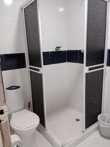 a small bathroom with a toilet and a shower at Hotel BM-17 Cerca Al Mar Con Aire Acondicionada y Wifi in Cartagena de Indias