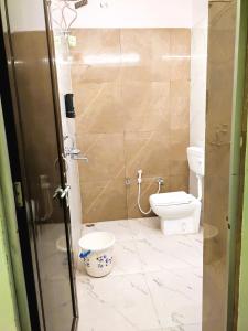 a small bathroom with a toilet and a shower at Yellow Homestay - Modern 2BHK AC stay in Jabalpur