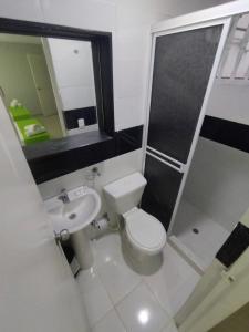 a small bathroom with a toilet and a sink at Hotel BM-17 Cerca Al Mar Con Aire Acondicionada y Wifi in Cartagena de Indias