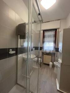 a bathroom with a glass shower and a toilet at Appartamento Sunflower in Viareggio