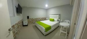 a small bedroom with a bed and a small table at Hotel BM-17 Cerca Al Mar Con Aire Acondicionada y Wifi in Cartagena de Indias