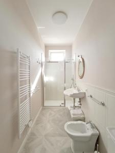 bagno bianco con servizi igienici e lavandino di Casa Vacanze Appartamento Bijoux a Civitanova Marche