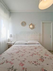 una camera da letto con un grande letto con un copriletto floreale di Casa Vacanze Appartamento Bijoux a Civitanova Marche