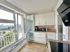 uma cozinha com armários brancos e uma grande janela em Design apartment Dresden centre - enjoy and relax em Dresden