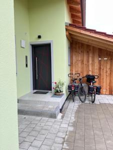 two bikes parked next to a building with a door at Ferienwohnung beim Mane in Schonstett